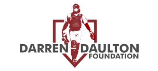 A baseball player is standing in front of the name darren daulton foundation.