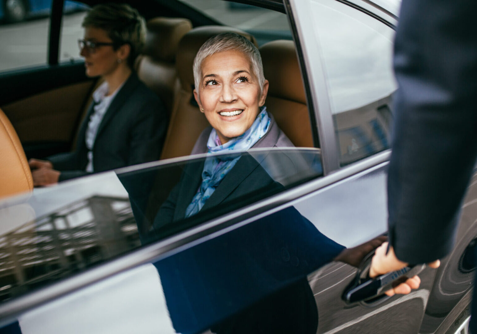 A woman sitting in the back of a car